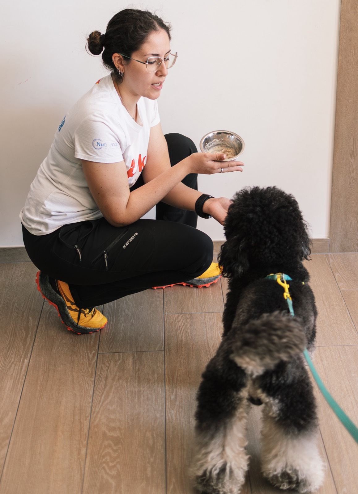 Educatrice Floky offre la ciotola a un cane durante la consulenza nutrizionale